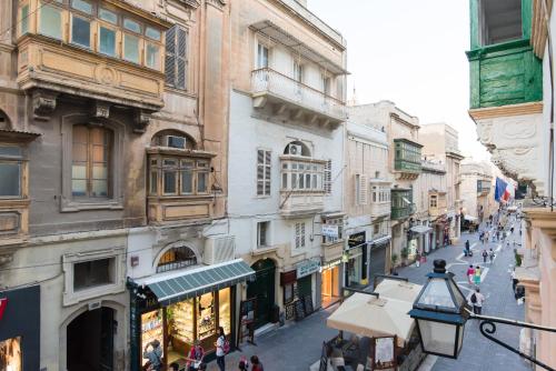 a street in the city with people walking around at Merkanti Apartments in Valletta