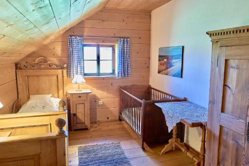 a bedroom with a crib in a log cabin at Ponzaunerhof in Hebertsfelden