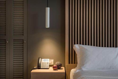 a bedroom with a phone on a nightstand next to a bed at Trianon Luxury Apartments & Suites in Chania Town