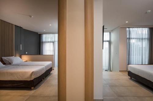 a bedroom with two beds and two windows at Trianon Luxury Apartments & Suites in Chania Town
