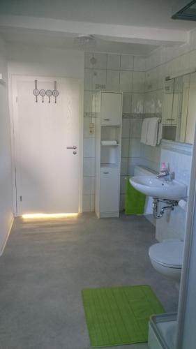 a white bathroom with a sink and a toilet and a sink at Haus Jungmann in Hallenberg