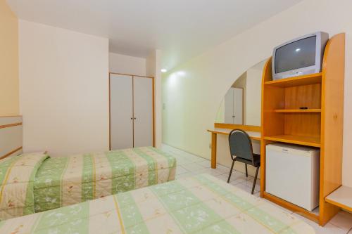 1 dormitorio con 1 cama, TV y escritorio en Tri Hotel Florianópolis, en Florianópolis