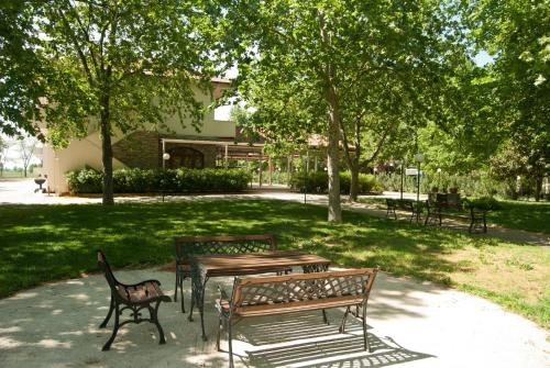 a picnic table and benches in a park at Yannis Hotel in Krinídhes