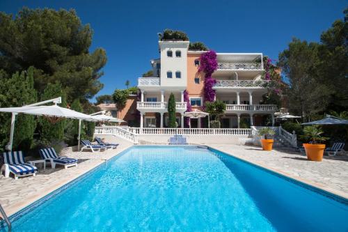 a villa with a swimming pool in front of a building at Appartement La Potinière in Saint-Raphaël