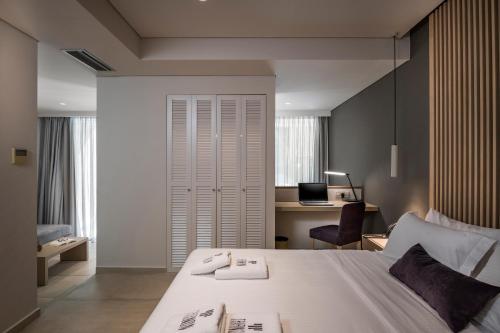 a bedroom with a large white bed and a desk at Trianon Luxury Apartments & Suites in Chania Town