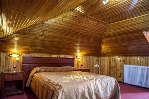 a bedroom with a bed in a wooden ceiling at Tasia Mountain Hotel in Chania
