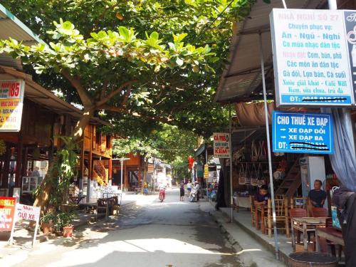 a street with shops and signs in a city at Cò's House in Mai Chau