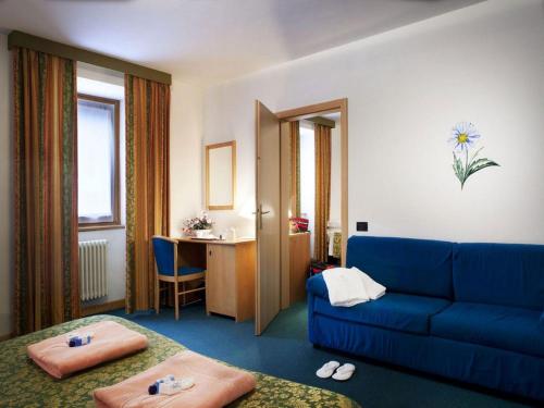 a living room with a blue couch and a table at Grand Hotel Rabbi in Bagni di Rabbi