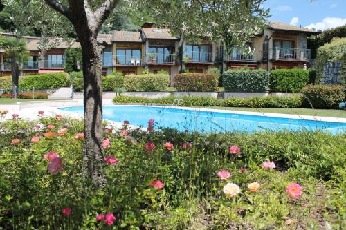 - une piscine fleurie devant un bâtiment dans l'établissement Garda Hills Residence, à Roe