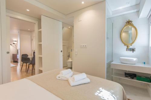ein Bad mit einem Bett, einem Waschbecken und einem Spiegel in der Unterkunft LovelyStay - Principe Real: modern and comfort! in Lissabon