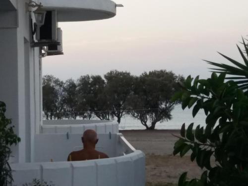 a man sitting in a bath tub outside of a house at Annabel Apartments in Theologos