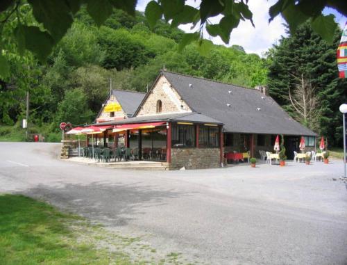 a building with tables and chairs in front of it at Camping Les Couesnons in Roz-sur-Couesnon