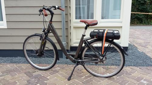 una bicicleta está estacionada frente a una casa en Hotel-Restaurant Het Rechthuis en Muiderberg