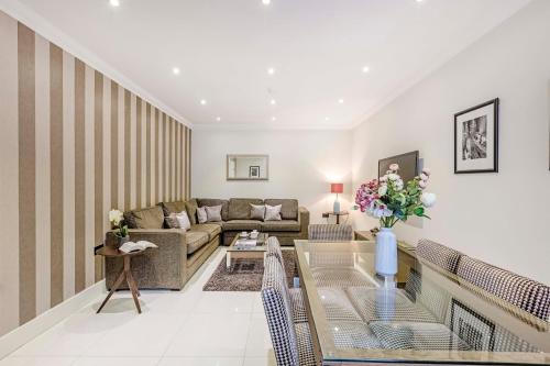a living room with a couch and a table at Ashburn Court Apartments in London