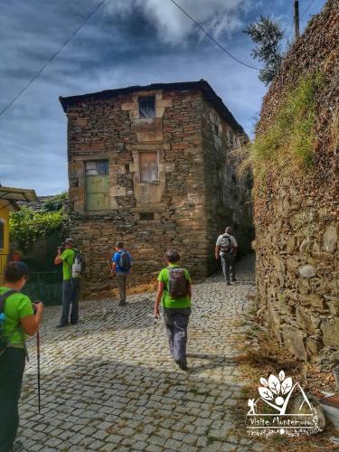 a group of people walking in front of a stone building at Casa Celeste in Castro Daire