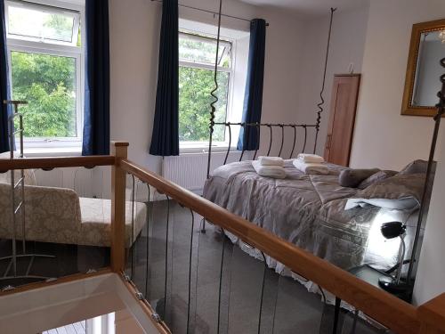 1 dormitorio con 1 cama y 2 ventanas en The Retreat at Plover Cottage Lindley, en Huddersfield