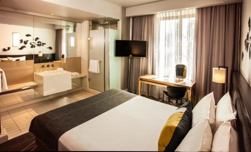 a hotel room with a bed and a bathroom at Piazza Hotel Montecasino in Johannesburg