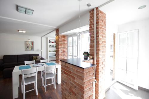 a kitchen and living room with a brick wall at BRICK APARTMENT ON MACEDONIA PEDESTRIAN STREET in Skopje