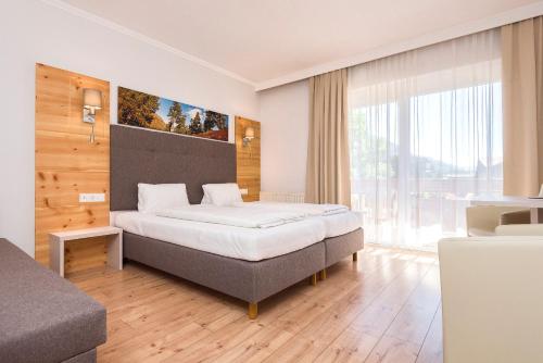 A bed or beds in a room at Genusshotel Almrausch