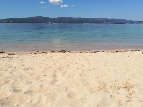 a sandy beach with the ocean in the background at Casa Guillan Illa de Arousa in Isla de Arosa