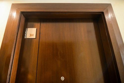 a wooden door with a sign on it at H&M One Palmtree Villas in Manila