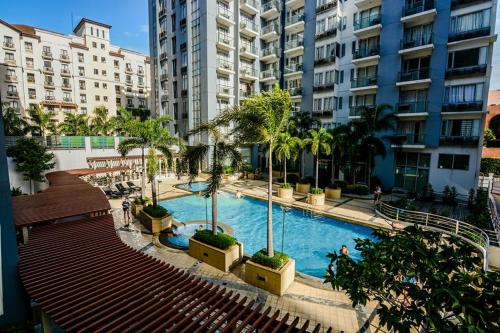 a large swimming pool with palm trees and buildings at H&M One Palmtree Villas in Manila