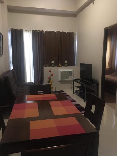 a living room with a table and a couch at H&M One Palmtree Villas in Manila