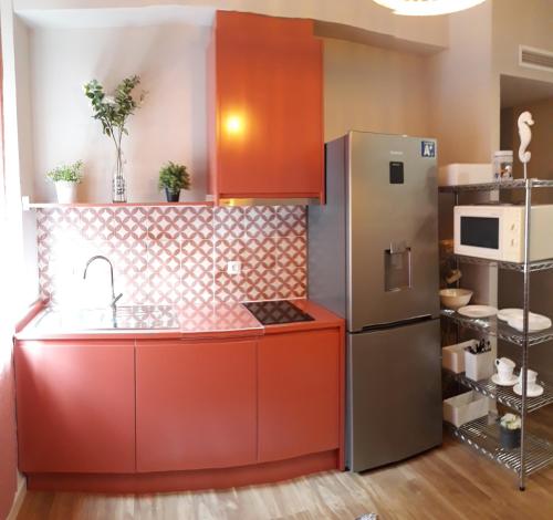コルドバにあるSEVILLA 15のキッチン(赤いキャビネット、ステンレス製の冷蔵庫付)