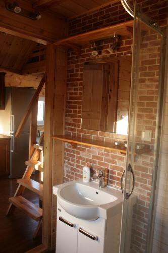 a bathroom with a sink and a brick wall at Domek Triftberg in Chojna