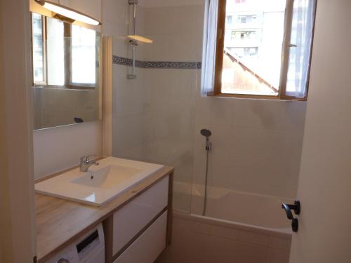 uma casa de banho com um lavatório e uma banheira em 4 Clarence app avec parking Hyper centre Thonon em Thonon-les-Bains