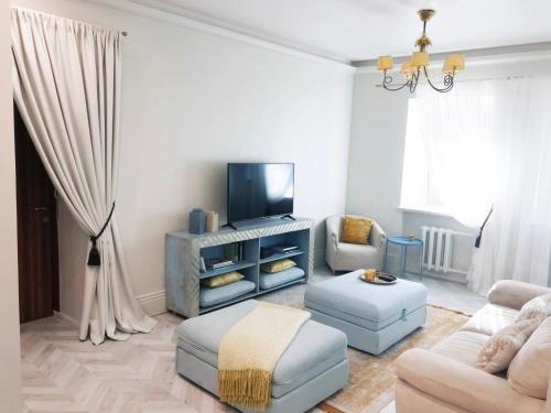 Una sala de estar con un sofá y un televisor. en Luxury old town apartment, en Vilna
