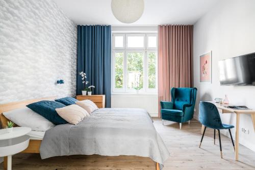 - une chambre avec un lit, un bureau et une chaise dans l'établissement Sanhaus Apartments - Fiszera 6, à Sopot