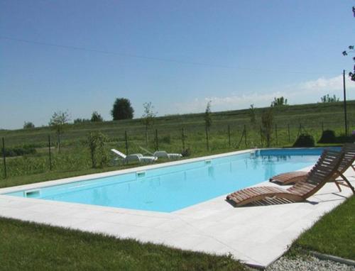 een zwembad met 2 ligstoelen bij Agriturismo Albero del Latte in Bagnolo San Vito