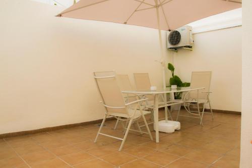 a table and chairs with an umbrella in a room at Apartamento Botavara in Málaga