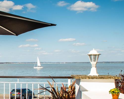 a sailboat in the water with a balcony with a boat at BEST WESTERN New Holmwood Hotel in Cowes