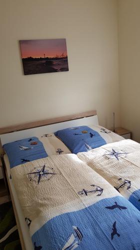ノルデンハムにあるWill's lütte Huusのベッドルーム1室(ベッド2台、青と白の毛布付)