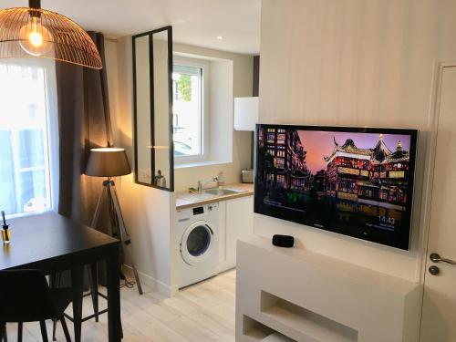 a living room with a flat screen tv on a wall at appartement le carnel in Lorient