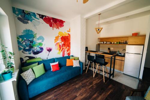 a living room with a blue couch and a kitchen at NS center apartment in Novi Sad
