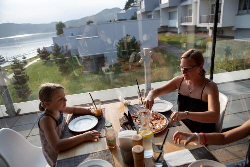 a woman and a little girl sitting at a table at Apartment Słoneczny Gródek 38 in Gródek Nad Dunajcem