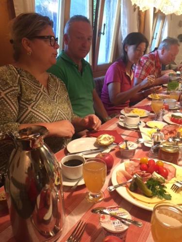 eine Gruppe von Menschen, die an einem Tisch mit Essen sitzen in der Unterkunft Landgasthaus Waldschänke in Emmendingen