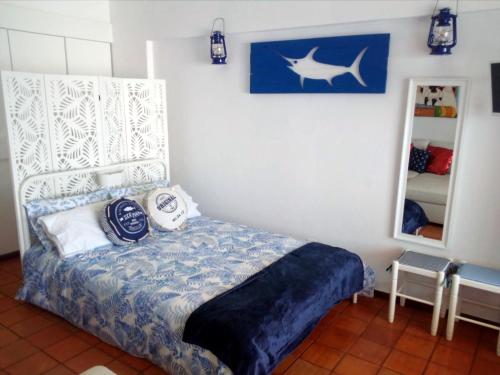 une chambre avec un lit et un miroir dans l'établissement Casa do Espadarte, à Sesimbra