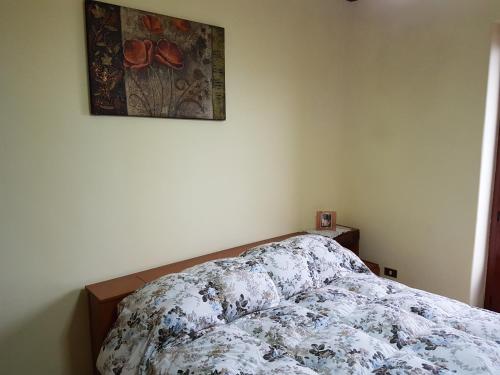 a bed in a bedroom with a picture on the wall at La Nicchia di Gangi in Gangi