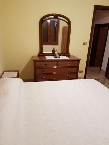 a bedroom with a bed and a dresser with a mirror at La Nicchia di Gangi in Gangi