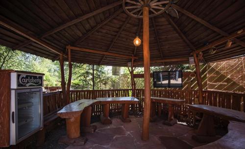 a wooden pavilion with benches and a tv in it at SKRZAT in Tumlin