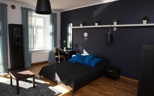 1 dormitorio con cama con almohadas azules y escritorio en EASY RENT Apartments - Konopnicka 11, en Lublin