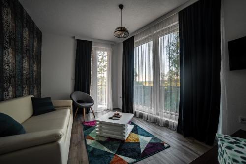 ein Wohnzimmer mit einem Sofa und einem Tisch in der Unterkunft Apartments and Rooms Villa Majestic in Bihać