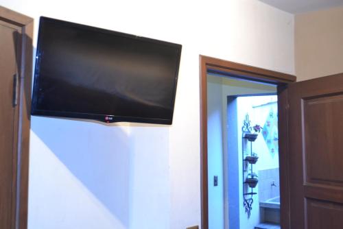 TV de pantalla plana colgada en la pared en Hostel Running Chaski, en Cochabamba