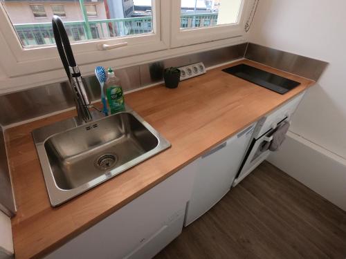 un comptoir de cuisine avec un évier et une fenêtre dans l'établissement Cozy Appartement Gare Pompidou, à Metz