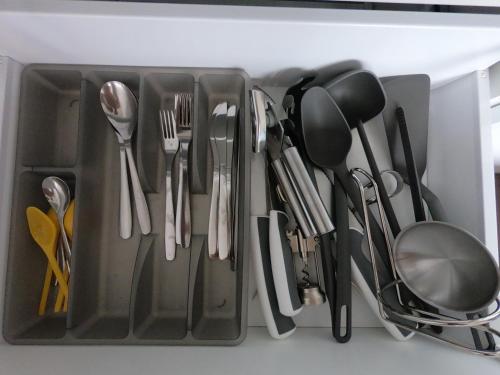 un tiroir rempli d'ustensiles dans un réfrigérateur dans l'établissement Cozy Appartement Gare Pompidou, à Metz