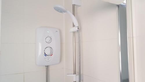 a shower with a shower head in a bathroom at Private Rooms just 19 minutes from Central London in Northfleet